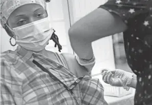  ?? SETH WENIG/AP ?? Shyrel Ritter, a certified nursing assistant at the Hebrew Home at Riverdale, receives her COVID-19 booster shot Monday at her workplace in New York.