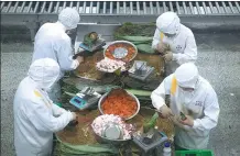  ?? GAO ERQIANG / CHINA DAILY ?? Workers wrap rice dumplings at Wufangzhai, making an average of 1.3 million dumplings daily.