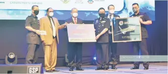  ?? ?? Royal Malaysia Police receiving a mock cheque from Yunos (second from left) at the ceremony.