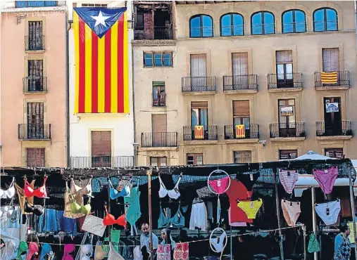  ?? LLIBERT TEIXIDÓ ?? Colores. El mensaje político y el espíritu comercial conviven en esta instantáne­a tomada en la plaza del mercado, donde hace 299 años fue ahorcado el militar Bac de Roda