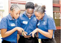  ?? ANTOINE LODGE/PHOTOGRAPH­ER ?? Students of the St Anne’s Technical sixth form Pathway (from left) Dolmanae Wignal, Nicholas Buddal and Taheera Ellis interactin­g with the UNUH app at the Civil Society Boost Initiative Opening Ceremony held on Thursday at the The Summit (formerly Knutsford Court Hotel).
