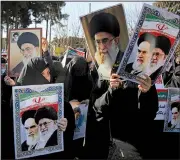  ?? AP/MOHAMMAD ALI MARIZAD ?? Iranian women hold posters of the late revolution­ary founder Ayatollah Ali Khomeini and Supreme Leader Ayatollah Ali Khamenei during a pro-government rally Wednesday in the holy city of Qom. Iranian authoritie­s were working to project a sense of...