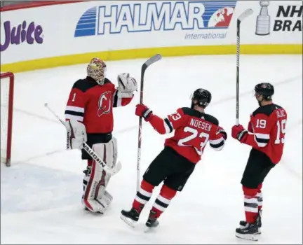  ?? JULIO CORTEZ - THE ASSOCIATED PRESS ?? New Jersey Devils players, from left, former Albany Devils goalie Keith Kinkaid (1), Stefan Noesen (23) and former Albany River Rats center Travis Zajac (19) celebrate after a win.