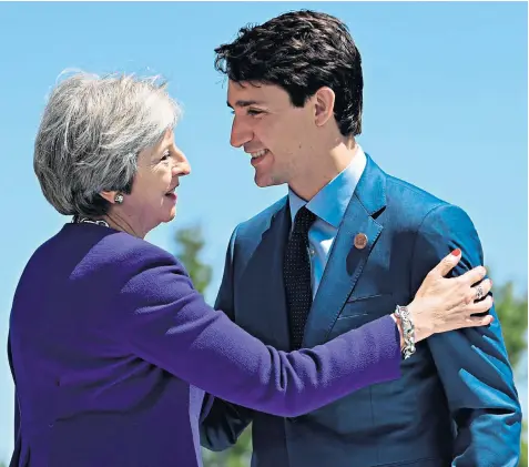  ??  ?? Justin Trudeau, the prime minister of Canada, greets Theresa May during the G7 summit in rural Charlevoix, Quebec. Mrs May and her Government face the return of the EU Withdrawal Bill to parliament next week