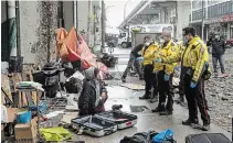  ?? CHRIS YOUNG
THE CANADIAN PRESS ?? Police officers speak to a homeless person as city workers clear an encampment on Toronto's Bay Street.