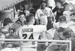  ?? MATIAS J. OCNER mocner@miamiheral­d.com ?? Avisail Garcia celebrates in the Marlins dugout after hitting a home run to spark a four-run second inning. Garcia drove in another run with a single in the seventh.