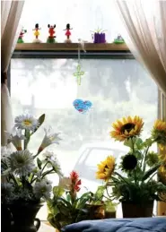  ??  ?? Flowers and mementos decorate a window in Mollie Abernathy's home.