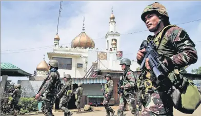  ?? ROMEO RANOCO / REUTERS ?? Government troops walk past a mosque before launching an assault against insurgents in Marawi City, southern Philippine­s, on Thursday.