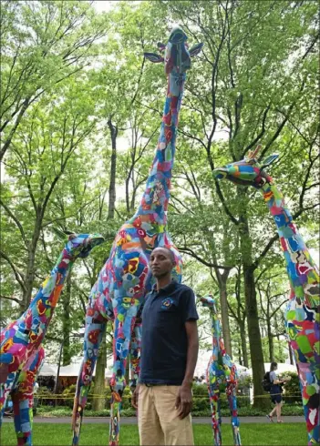  ?? Delia Johnson/Post-Gazette ?? Kenyan artist Jonathan Lo with the animal sculptures that he created from recycled flip-flops. Lo and the organizati­on Ocean Sole Africa collect flip-flops that wash ashore in the Indian ocean. “We have many flip-flops in the ocean so we wanted to move it from the water to save marine life, we thought the best way was out of art so that’s what made me be inspired.”