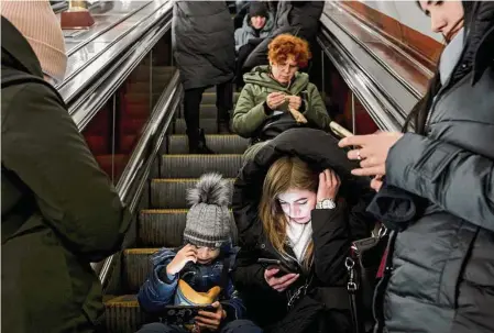  ?? Emile Ducke/New York Times ?? Civilians shelter in a subway station Friday as an air raid alarm sounds in Kyiv, Ukraine. Russia increasing­ly targeted Ukraine’s already battered infrastruc­ture. Rockets, cruise missiles and drones hit cities all around the country on Friday.