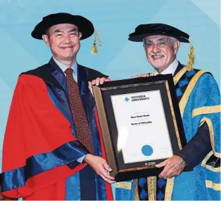  ??  ?? Dr Jason Cheok Boon Chuan (left) receiving his doctorate from Victoria University chancellor George Pappas.