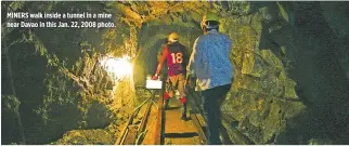  ??  ?? MINERS walk inside a tunnel in a mine near Davao in this Jan. 22, 2008 photo.