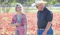  ?? AP PHOTO ?? In this April 2017 photo, TV travel show host Samantha Brown walks through a field of flowers in Fredericks­burg, Texas, with John Thomas, the owner of Wildseed Farms.