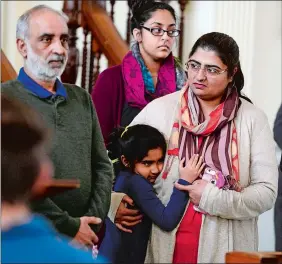  ?? SARAH GORDON/THE DAY ?? Zahida Altaf, right, of New Britain, is hugged by her daughter Roniya as she stands with her husband, Malik Naveed Bin Rehman of New Britain, and their daughter during a meeting with U.S. Sen. Richard Blumenthal on Sunday at at the First Congregati­onal...