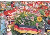  ?? FOTO: AP ?? Am Tatort stehen Kerzen und Blumen. Vermutlich haben Rechte die Deutschlan­ddeko niedergele­gt.