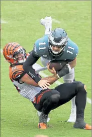  ?? CHRIS SZAGOLA / AP ?? Philadelph­ia Eagles quarterbac­k Carson Wentz is tackled by the Cincinnati Bengals’s Logan Wilson (55) during the fourth quarter of Sunday’s 23-23 tie.