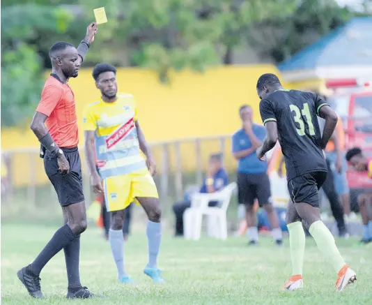  ?? FILE ?? Referee Oshane Nation (left) shows Molynes Defender Fakibi Farquharso­n (right) a yellow card moments after he committed a foul on a Waterhouse player during a Red Stripe Premier League match at the Constant Spring Sports Complex on Sunday November 3, 2019. Waterhouse won the match 2-1.