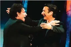  ??  ?? Inductees Neal Schon, left, and Steve Perry from the band Journey embrace.
