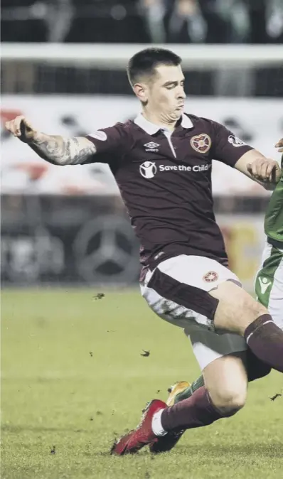  ??  ?? 0 Hearts duo Jamie Walker, left, and Prince Buaben make a combined effort to halt Hibs midfielder Marvin Bartley during Wednesday night’s goalless Edinburgh derby at Tynecastle Park.