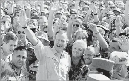  ?? J. Scott Applewhite Associated Press ?? ARCHITECT OF THE ‘NEW WORLD ORDER’ Bush visits soldiers at an air base in Dhahran, Saudi Arabia, in 1990. He sent U.S. forces to the Middle East after Saddam Hussein’s army invaded Kuwait. Despite the swift victory in early 1991, Bush failed to win reelection.