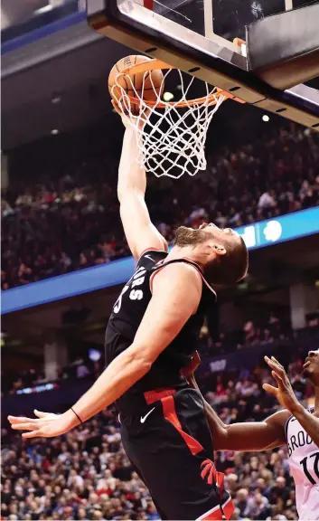  ?? FRANK GUNN/THE CANADIAN PRESS ?? Raptors centre Marc Gasol makes a reverse dunk as Brooklyn Nets forward Ed Davis looks on during Toronto’s 127-125 win on Monday. Gasol had 16 points in his home debut for the Raps.