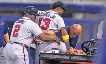  ?? AP PHOTO/LYNNE SLADKY ?? Atlanta Braves right fielder Ronald Acuña Jr. is helped onto a medical cart after trying to make a catch on an inside-the-park home run hit by the Miami Marlins’ Jazz Chisholm Jr. during the fifth inning of Saturday’s game in Miami. Atlanta won 5-4, but Acuña did not return.