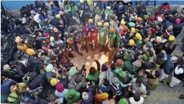  ?? — PTI ?? Farmers burn copies of the farm laws during ‘Lohri’ festival amid the ongoing protest at the Ghazipur border in New Delhi on Wednesday.