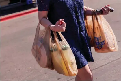  ?? Photograph: Shelby Tauber/Bloomberg via Getty Images ?? A shopper carries bags outside a Kroger grocery store in Dallas, Texas, on 21 February 2024.