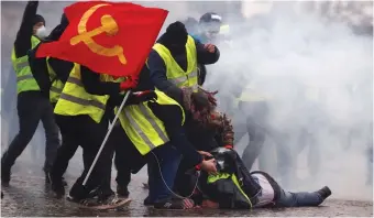  ?? (Christian Hartmann/Reuters) ?? PROTESTERS WAVE a communist flag last week during a demonstrat­ion by the ‘yellow vests’ movement near the Arc de Triomphe in Paris.