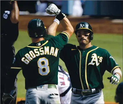  ?? KEVORK DJANSEZIAN — GETTY IMAGES ?? Oakland’s Ramon Laureano accepts congratula­tions from Robbie Grossman after his homer against Houston in the fifth inning of ALDS Game 4.