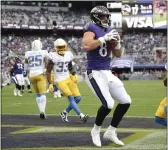  ?? NICK WASS — THE ASSOCIATED PRESS ?? Baltimore Ravens tight end Mark Andrews, center, looks on after catching a touchdown pass from quarterbac­k Lamar Jackson, not visible, during the second half Sunday against the Los Angeles Chargers in Baltimore.