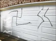  ?? JUSTIN MADDEN / CLEVELAND.COM ?? Swastikas were spray painted on Carlos and Dawn Berry’s garage and vinyl siding.