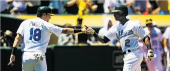  ?? Gabrielle Lurie / The Chronicle ?? Khris Davis (2) is congratula­ted by Chad Pinder after Davis plated Pinder with his 18th homer.