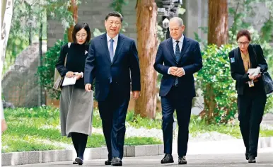  ?? Photo: Xinhua ?? President Xi Jinping chats with German Chancellor Olaf Scholz during a stroll yesterday as part of their discussion­s in Beijing.