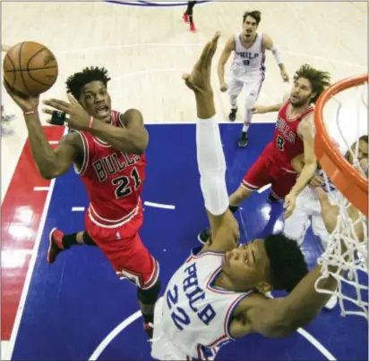  ?? CHRIS SZAGOLA — THE ASSOCIATED PRESS ?? Chicago’s Jimmy Butler, left, elevates for a shot over the 76ers’ Richaun Holmes during Thursday night’s game at Wells Fargo Center. Butler posted a triple-double as the Bulls ran away with a 102-90 win.