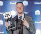  ?? JASON FRANSON THE CANADIAN PRESS ?? Calgary Stampeders quarterbac­k Bo Levi Mitchell holds his award as CFL’s most outstandin­g player on Thursday.