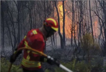  ?? PAULO DUARTE — THE ASSOCIATED PRESS ?? Portuguese firefighte­rs work to stop a forest fire from reaching the village of Figueiro dos Vinhos in central Portugal, Sunday. Portugal’s president says the country’s pain “knows no end” as it mourns at least 62 people killed in the deadliest...