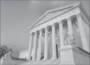  ?? The Associated Press ?? SUPREME COURT: In this Feb. 13 photo, people stand on the steps of the Supreme Court at sunset. The Supreme Court is returning to the familiar intersecti­on of race and politics, in a pair of cases examining redistrict­ing in North Carolina and Virginia....