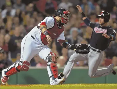  ?? STAFF PHOTO BY CHRISTOPHE­R EVANS ?? CAN'T CATCH THEM: Sandy Leon watches his throw to second base last night as the Indians' Yan Gomes scores behind him. The Red Sox dropped their third straight, losing to the Indians, 6-3, at Fenway.