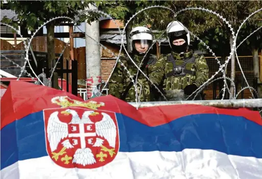  ?? (ZVECAN, 1ER JUIN 2023/GEORGI LICOVSKI/EPA) ?? Des soldats de la KFOR montent la garde devant la municipali­té de Zvecan, qui se trouve assiégée par une foule éparse de Serbes.