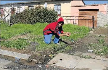  ?? Pictures: FREDLIN ADRIAAN ?? WATER NIGHTMARE: Ashton Harris points to a trench he had to dig to lead water out of the yard of his Gelvandale house, which is built on a spring