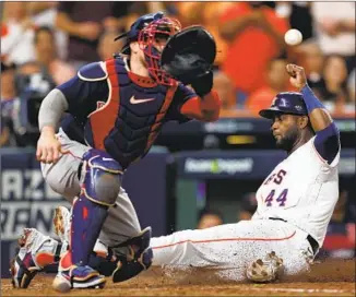  ?? Elsa Garrison Getty Images ?? YORDAN ALVAREZ slides home with a run in the sixth inning, beating the throw to Boston catcher Christian Vázquez, for Houston’s second run. Alvarez was selected series MVP.