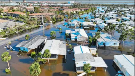  ?? AP PHOTOS ?? Above, rescue personnel search a flooded trailer park in Fort Myers, Fla. Top left, residents check on one another in a flooded neighborho­od in Orlando., Fla. Top right, Jordan Gaudet of Baton Rouge, La., surveys a boat on a piling in a marina in Fort Myers.