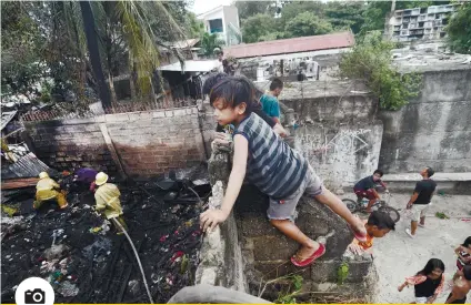  ?? PHOTO BY ALAN TANGCAWAN ?? FIRE CASUALTY: There’s nothing like a fire to pique the interest of the young. The incident, which happened past 4 p.m. on Monday, Dec. 3, destroyed the house of 50-year-old Carmelo Ansag inside the Quijano Compound in Barangay Calamba, Cebu City. /