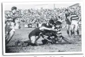  ??  ?? Fitzroy’s Brian Clements and Geelong’s Polly Farmer (right) wait for the ball to be cleared in tough conditions in 1963.
