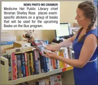  ?? NEWS PHOTO MO CRANKER ?? Medicine Hat Public Library chief librarian Shelley Ross places eventspeci­fic stickers on a group of books that will be used for the upcoming Books on the Bus program.