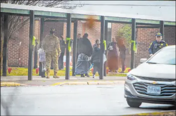  ?? John C. Clark The Associated Press ?? Parents escort their children to Richneck Elementary School on Monday in Newport News, Va. It was closed Jan. 6 after a 6-year-old intentiona­lly shot his first grade teacher.