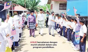  ??  ?? JUSLIE bersalaman dengan murid sekolah dalam satu program pendidikan.