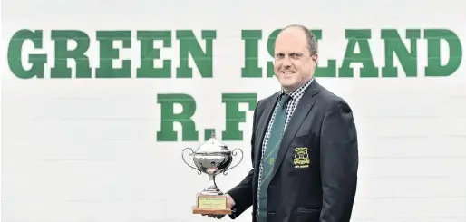  ?? PHOTO: PETER MCINTOSH ?? Green and gold through and through . . . Gareth Weathersto­n at the Green Island Rugby Football Club this week with the trophy awarded for Otago rugby volunteer of the year.