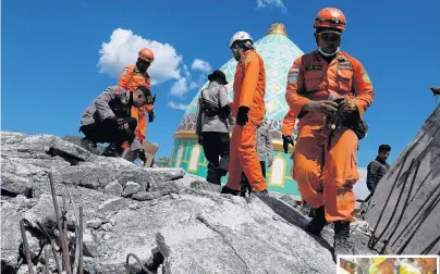  ?? PHOTOS: REUTERS ?? Grim search . . . Rescuers and policemen walk on top of a collapsed mosque in Pemenang as they try to find earthquake survivors yesterday. Right: Rescue workers in Tanjung extract a woman who survived after being trapped in rubble since the quake,